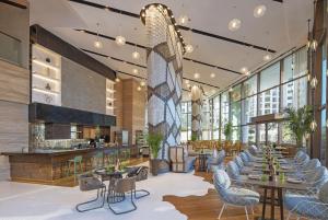 a restaurant with tables and chairs and windows at Andaz Dubai The Palm, By Hyatt in Dubai