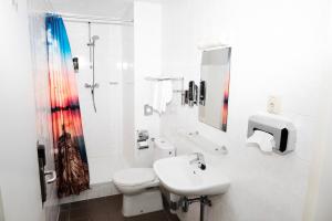 a white bathroom with a sink and a toilet at Amsterdam Teleport Hotel - Free Parking in Amsterdam +20 photos
