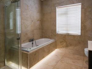 a bathroom with a tub and a glass shower at Dawn Chorus house, Ravensdale in Dundalk