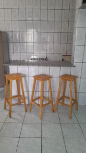 two wooden stools sitting next to a counter in a kitchen at Villagio Vistamar Ilha Comprida in Ilha Comprida +44 photos