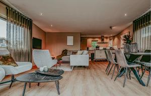 a living room with chairs and a table and a kitchen at Woude in Uitgeest