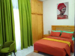 a bedroom with a bed and a green curtain at La Rouah Mishkan in Dakar