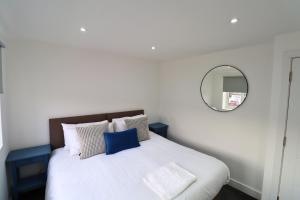 a bedroom with a large bed with a mirror at London Mitcham Beautiful Three Bedroom House in Mitcham