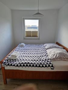 ein Schlafzimmer mit einem Bett mit einer blau-weißen karierten Matratze in der Unterkunft Haus Noah in Sierosław