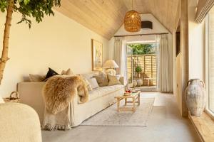 a living room with a couch and a table at Luxury Cotswold Retreats in Moreton in Marsh