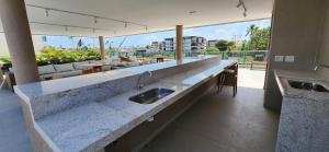 a kitchen with a counter with a sink in it at Malia Beach Experience - Studios em Muro Alto por Yolo in Ipojuca