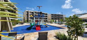 a pool with a slide and a playground at Malia Beach Experience - Studios em Muro Alto por Yolo in Ipojuca