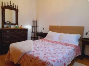 a bedroom with a bed with a dresser and a mirror at Praia Espinho in Espinho