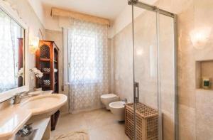 a bathroom with a toilet and a sink and a shower at VILLA MAGNOLIA in Cavallino-Treporti