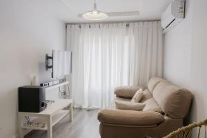 a living room with a couch and a tv at Apartamento cerca del Pilar in Zaragoza