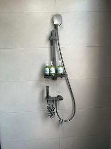 Una ducha con cuatro botellas en una pared. en Wangxian Mountain Retreat B&B-Wangxian Valley Scenic Area, en Qiaotou