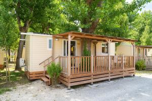 a tiny house with a porch and a deck at Club del Sole Rimini Family Resort in Rimini