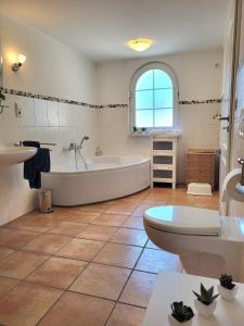 a bathroom with a tub and a toilet and a sink at 105 qm Whg mit gehobener Ausstattung in Homberg Ohm in Homberg Ohm