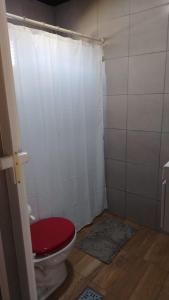 a bathroom with a toilet with a red seat at La Mini Polo in General Rodríguez