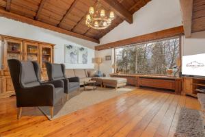 a living room with a couch and a tv at Luxus Ferienhaus Salzburg Chalet mit Pool, Sauna, Whirlpool, Kamin in Grossgmain