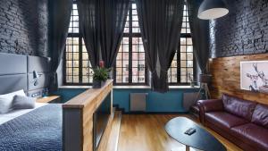 Una sala de estar con un sofá y algunas ventanas. en Black Swan House, Old Town, en Gdansk