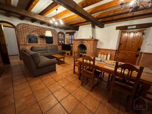 a living room with a couch and a table and a fireplace at La Tahona Vieja in El Barraco