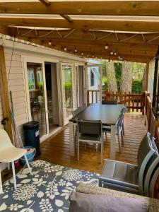 莱马特Mobil home climatisé 6,8 Pers SIBLU BONNE ANSE PLAGE LA PAMYRE LES MATHES的露台上有一张桌子和几把椅子