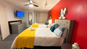 a bedroom with a large bed with a yellow and red wall at Whimsical Condo 1.5M from Disney in Orlando +63 photos