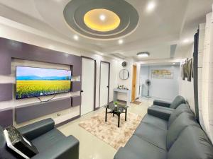 a living room with a couch and a flat screen tv at MC2 Homestay Butuan in Butuan