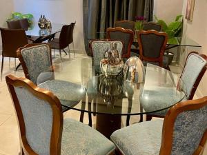 a glass table in a room with chairs at Adiel Guesthouse in Cape Town