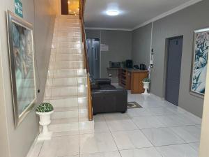 a living room with a black couch and a staircase at Adiel Guesthouse in Cape Town