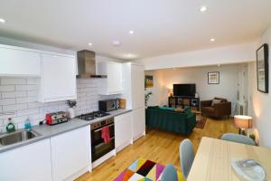a kitchen and living room with a table and a counter top at London Mitcham Stunning Two Bedroom Apartment in Mitcham