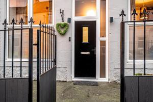 a black door of a house with a wreath on it at The Lang Toun Bothy - close to Edinburgh by Urban Haggis Stays in Kirkcaldy