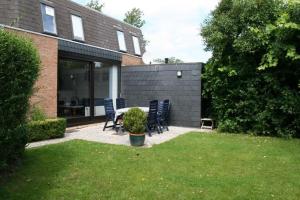 a patio with chairs and a table in a yard at Heggerank 54 in Nieuwvliet