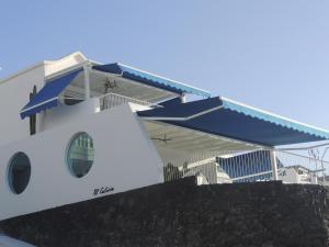 una casa con techo azul y pared de piedra en Luxury Sea Front Caleton 40, en Puerto del Carmen