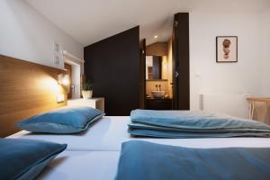 a bedroom with two beds with blue pillows at Fine Rooms Vipava in Vipava
