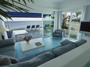 a living room with a couch and a view of the ocean at Luxury Sea Front Caleton 40 in Puerto del Carmen