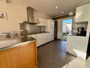 a kitchen with white cabinets and a large window at Quiberon : Maison 3 pièces, 105m², parking, quartier calme proche plage - FR-1-478-305 in Quiberon