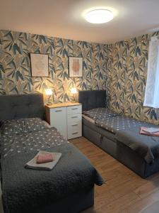 a bedroom with two beds and a wall with a wallpaper at Apartament Japko in Gliwice