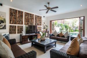 a living room with a couch and a tv at Villa Annecy in Seminyak