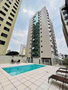 a swimming pool with two tall buildings at LK Barro Preto 11 in Belo Horizonte