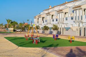 a playground with colorful play equipment on a lawn at Casa Rio Madera in San Pedro del Pinatar