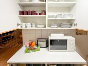 a kitchen counter with a microwave and some dishes at Holiday Home Ylläskakkonen b9 by Interhome in Ylläsjärvi