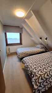 a bedroom with two beds and a window at Fantastic home Beach Life 39A in De Koog