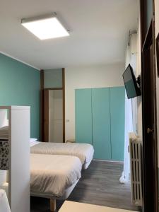a room with two beds and a flat screen tv at Nice Room in Busto Arsizio