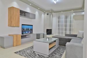 a living room with a couch and a tv at Poli's Luxury suite @ N. Moudania in Nea Moudania