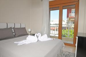 two white swans sitting on top of a bed at Poli's Luxury suite @ N. Moudania in Nea Moudania