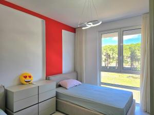 una camera da letto con un letto e una parete rossa di SwissSweet Apartment - 297 a Durrës