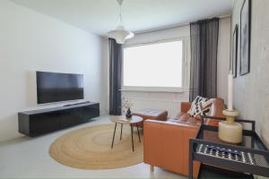 クオピオにあるModern 42m2 Apartment with free parkingのリビングルーム(オレンジ色のソファ、テレビ付)