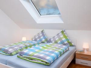 a bedroom with a bed with pillows and a skylight at Apartment Schleichert-1 by Interhome in Barkholt