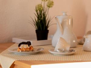 a table with two plates of food and a vase at Apartment Schleichert-1 by Interhome in Barkholt