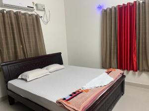 a bed in a room with curtains at Premium 2BHK-Gachibowli -Walk to AIG Microsoft DLF in Gachibowli