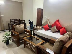 a living room with a couch and a chair at 2 BHK Gachibowli AIG #102 in Hyderabad +35 photos