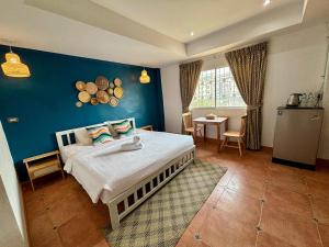 a bedroom with a bed and a blue wall at Charm Hostel at Jomtien in Jomtien Beach
