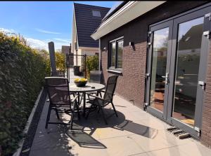 a patio with a table and chairs on a balcony at ' Zilten Huus Zoutelande in Zoutelande